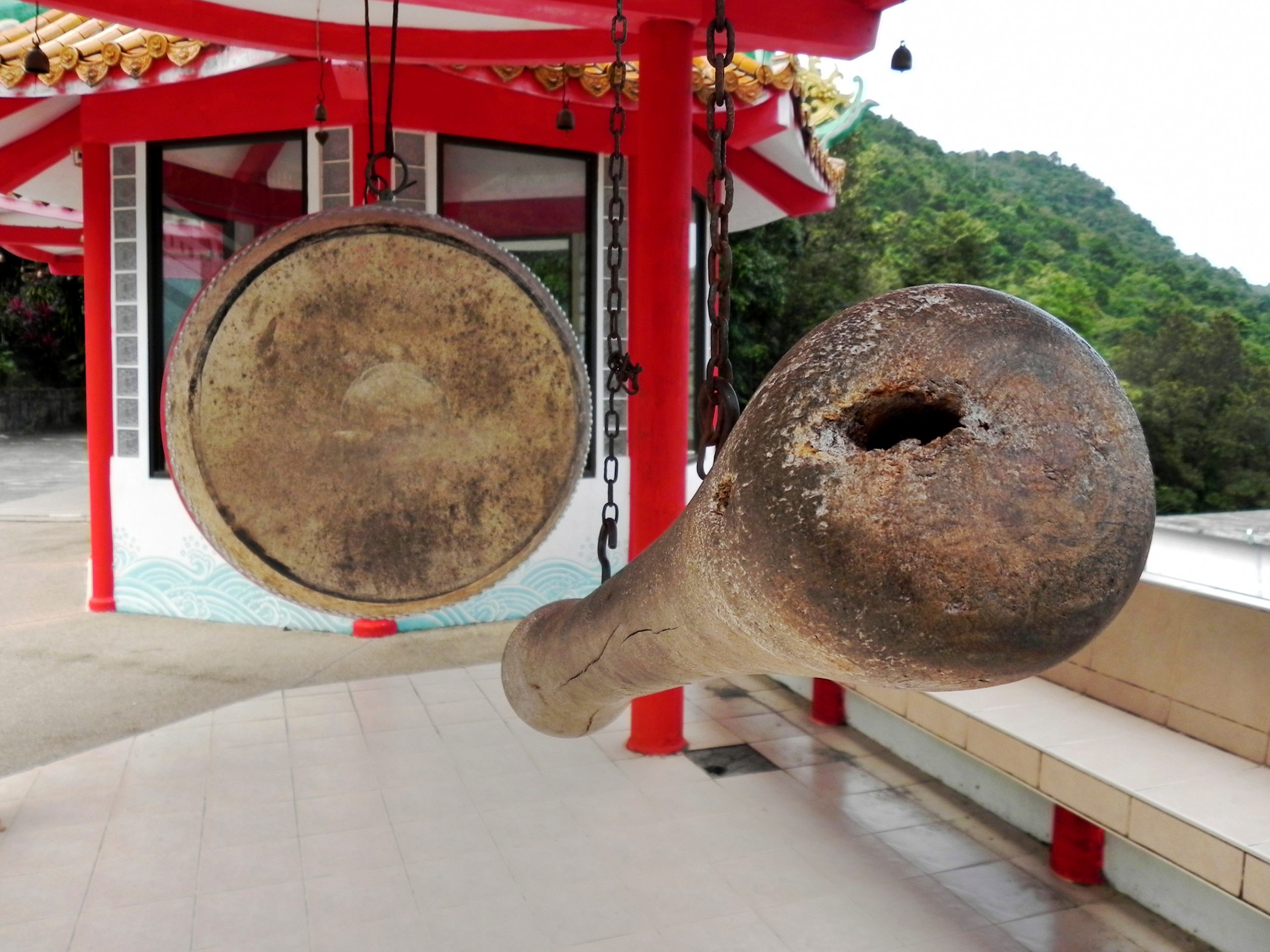 a drum and a baton hang in a Chinese temple.